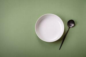 Empty round ceramic plate on a plain background, flatley with copy space photo