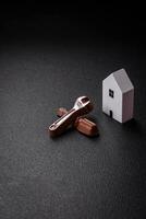 Repair or home improvement tools and a house model on a plain background photo