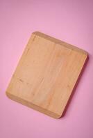 Empty wooden rectangular cutting board on a plain background, flatley with copy space photo