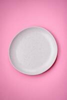 Empty round ceramic plate on a plain background, flatley with copy space photo