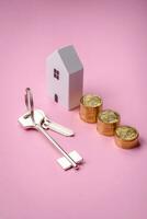 A small wooden house and keys as an idea for investing in your own home photo