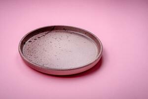 Empty round ceramic plate on a plain background, flatley with copy space photo