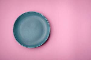 Empty round ceramic plate on a plain background, flatley with copy space photo