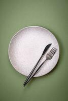 Empty round ceramic plate on a plain background, flatley with copy space photo