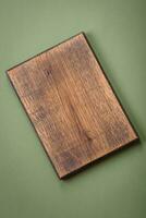 Empty wooden rectangular cutting board on a plain background, flatley with copy space photo