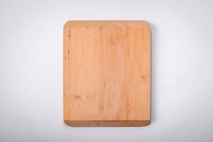 Empty wooden rectangular cutting board on a plain background, flatley with copy space photo