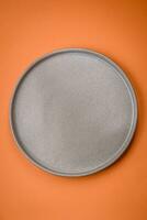 Empty round ceramic plate on a plain background, flatley with copy space photo