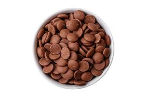 Round granules of sweet confectionery chocolate as an ingredient for preparing desserts photo