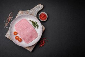 Delicious fresh ham cut into slices with salt, spices and herbs photo