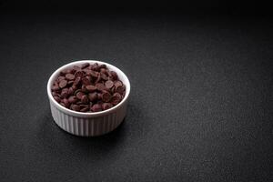 Round granules of sweet confectionery chocolate as an ingredient for preparing desserts photo