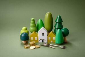 A small wooden house, money and keys as an idea for investing in your own home photo