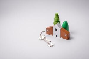 A small wooden house and keys as an idea for investing in your own home photo