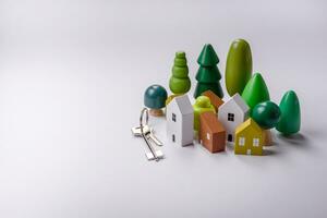 A small wooden house and keys as an idea for investing in your own home photo