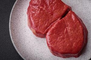 Fresh juicy raw filet mignon with salt, spices and herbs photo