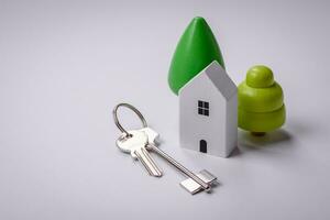 A small wooden house and keys as an idea for investing in your own home photo