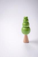 Wooden model of a tree with a green crown and trunk on a white background photo