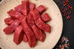 Juicy fresh raw beef meat with salt, spices and herbs photo