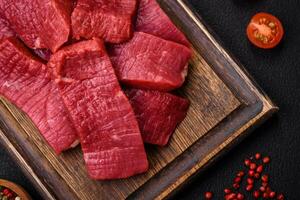 Juicy fresh raw beef meat with salt, spices and herbs photo