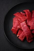 Juicy fresh raw beef meat with salt, spices and herbs photo