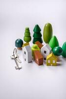 A small wooden house and keys as an idea for investing in your own home photo