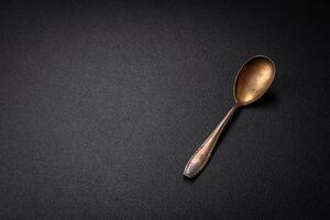 Empty metal spoon on dark textured concrete background photo