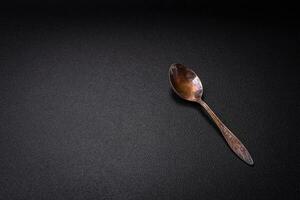 Empty metal spoon on dark textured concrete background photo