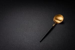 Empty metal spoon on dark textured concrete background photo