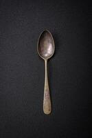 Empty metal spoon on dark textured concrete background photo