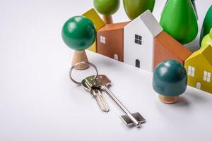 A small wooden house and keys as an idea for investing in your own home photo