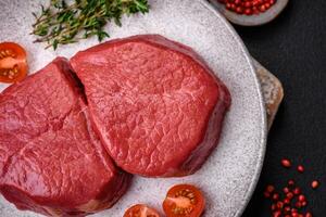 Fresh juicy raw filet mignon with salt, spices and herbs photo