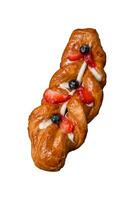 Delicious fresh crispy pastry in the form of a pigtail with strawberries and blueberries photo