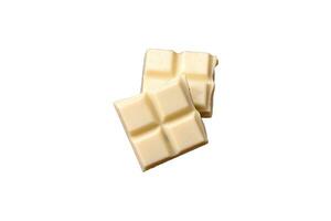 Delicious sweet white chocolate broken into cubes on a wooden cutting board photo