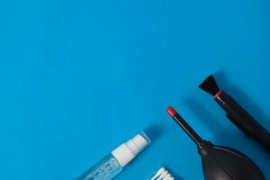 Cleaning set for camera air blower, microfiber, brush and more. Isolated on blue background photo