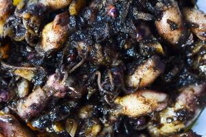 Close up Tumis Cumi, Oseng cumi or Stir Fried Squid placed on tranparent plate of glass isolated on white background. Indonesian food photo