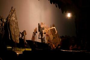 A man perform with wayang or traditional javanese puppet on stage at night. Tuban, Indonesia - 22 September, 2023. photo