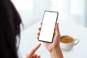 Woman in a coffee shop using a smartphone with an isolated screen for mockup. Ideal for showcasing mobile usability in a casual coffee time setting photo