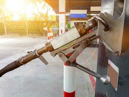 Closeup gas dispenser for automobile at gas station on blurry with sun flare and lens flare background. photo