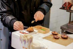 Hands of Japanese chef cooking sasemi seafood for sell to customer in Kuromon market, Osaka, Japan. photo