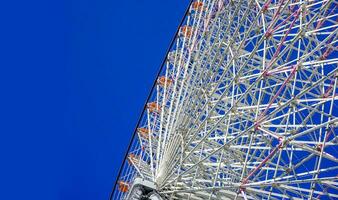 Closeup and crop Tempozan Giant Ferris Wheel on bright blue sky background with space for texts. photo