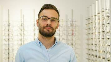 Man Trying On Eyeglasses In Optics Store. Glasses Shop video