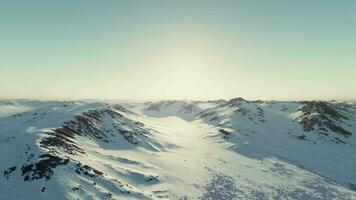 uma majestoso Nevado montanha alcance iluminado de a Sol video