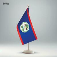Flag of Belize hanging on a flag stand. vector