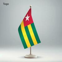 Flag of Togo hanging on a flag stand. vector