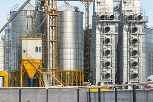 modern agro-processing plant for processing and silos for drying cleaning and storage of agricultural products, flour, cereals and grain in snow of winter field photo