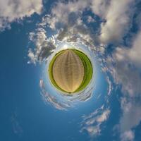 sencillo minúsculo planeta sin edificios en azul cielo con hermosa nubes transformación de esférico panorama 360 grados esférico resumen aéreo vista. curvatura de espacio. foto