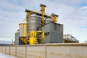 moderno agroprocesamiento planta para Procesando y silos para el secado limpieza y almacenamiento de agrícola productos, harina, cereales y grano en nieve de invierno campo foto