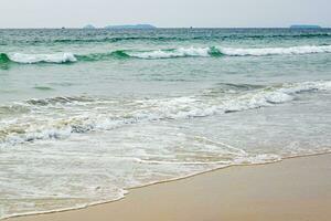 foam of sea or ocean waves against the backdrop with palms photo