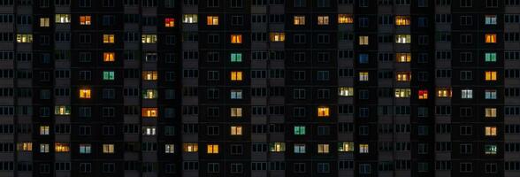 flat night panorama of multicolor light in windows of multistory buildings as concept for 2024 new year photo