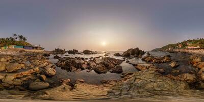 full hdri 360 panorama view on ocean on shore with rocks at sunset in equirectangular projection with zenith and nadir. VR AR content photo