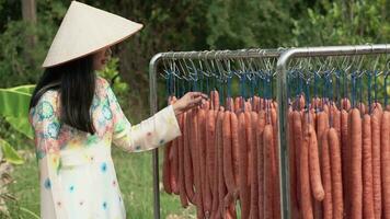 Vietnamese beautiful women in traditional costumes produce chinese sausages. Chinese sausages are one of the popular food during Chinese New Year. video